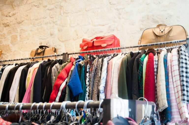 Folded secondhand clothing organized on shelves ready to be listed on Vinted