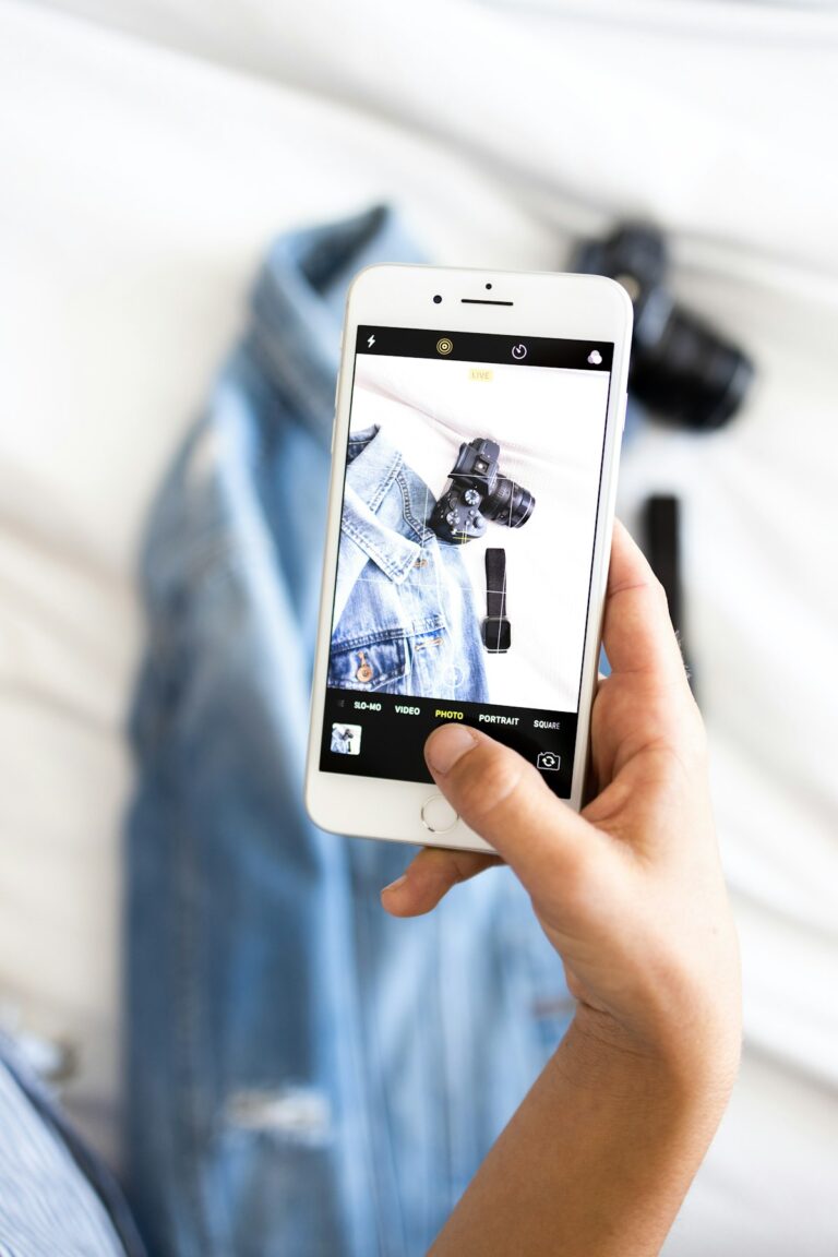 Seller photographing a denim jacket with a smartphone for a listing