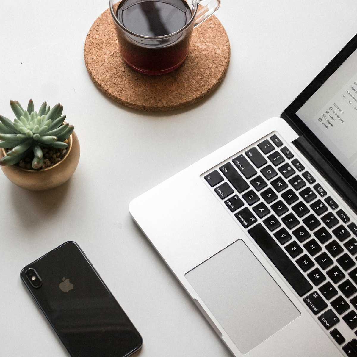 Smartphone and laptop on a desk for managing buyer messages