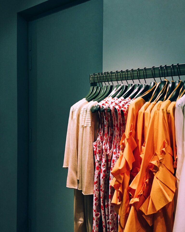 Rack of warm-toned seasonal clothing on hangers